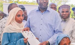 A member of the Pemba Community receives their IDs waiting form after successful registration